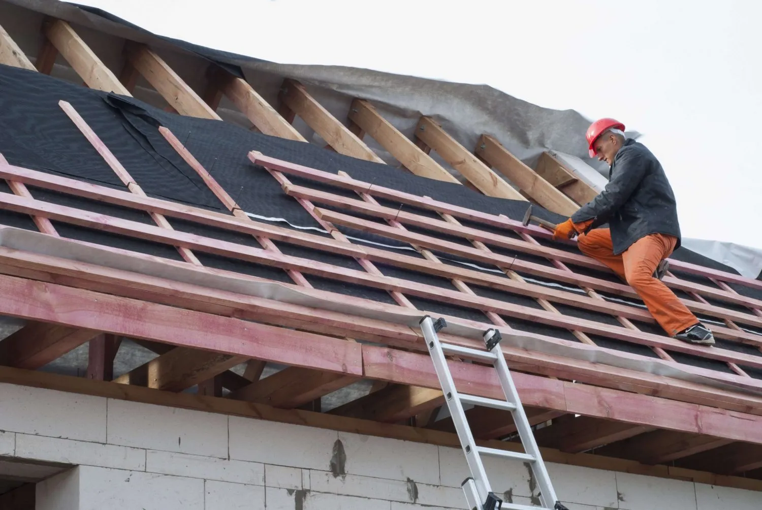 Full roof restoration services. Roofer working on wood roof deck.
